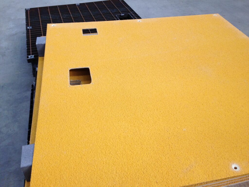 a piece of GRP yellow flat sheet with a gritted top and a two small cutouts in the top left corner